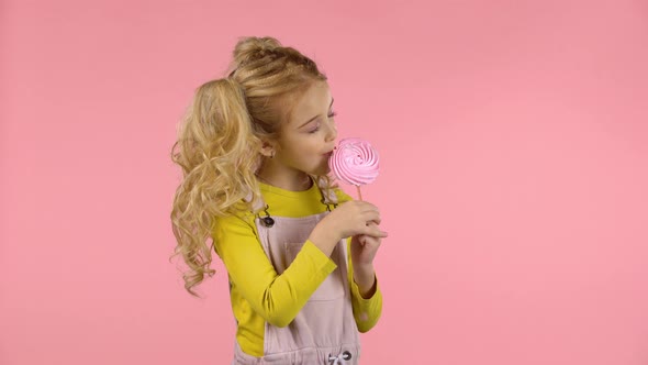 Pretty Girl Is Tasting Pink Candy on the Stick