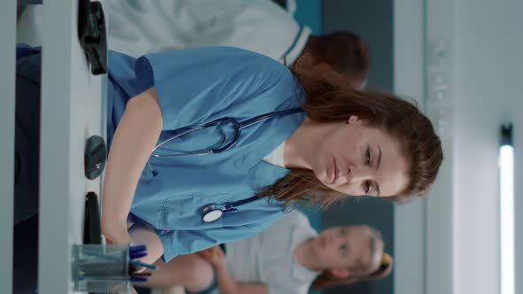 Vertical Video Portrait of Medical Assistant Using Computer to Work on Appointment