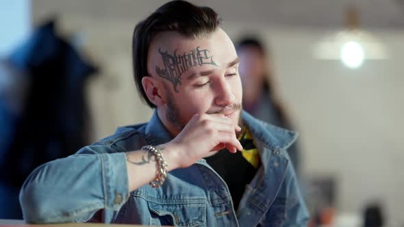 Portrait of Young Tattooed Pierced Caucasian Man Sitting in Bar Waiting for Order