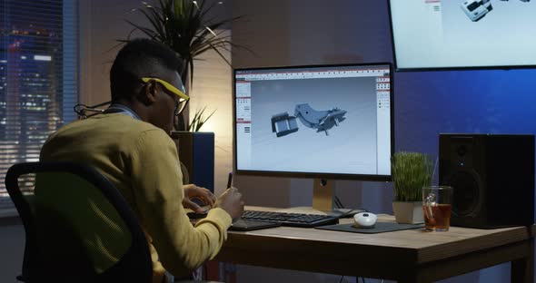 Young Man Siiting Back and Editing an Image on His Computer