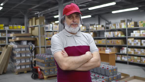 Portrait of Mature Warehouse Worker in Uniform Standing in Distribution Center