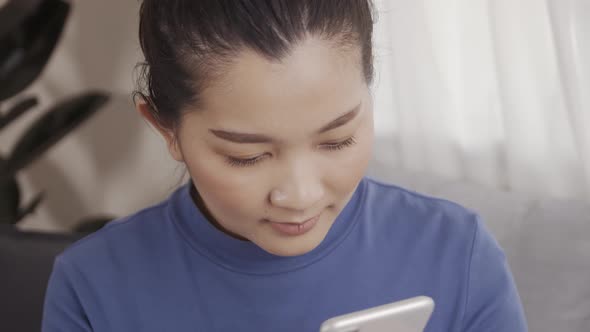 Asian woman on using a smartphone with AI voice command for a chat with customer