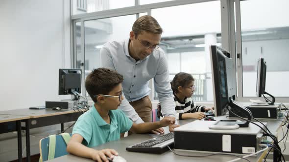 Cheerful Teacher and Schoolboy Working on Computer Together