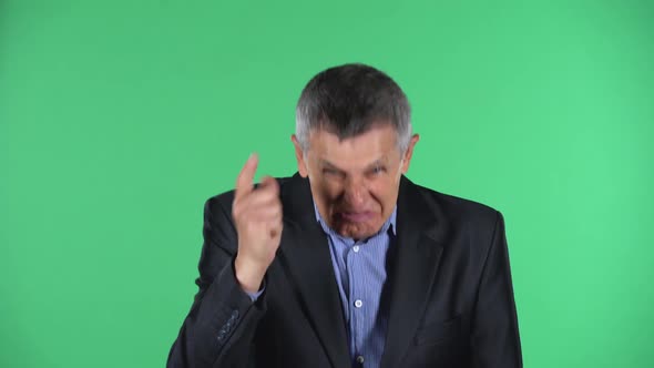 Portrait of Aged Man Is Scolding, Shaking His Index Finger, Isolated Over Green Background.