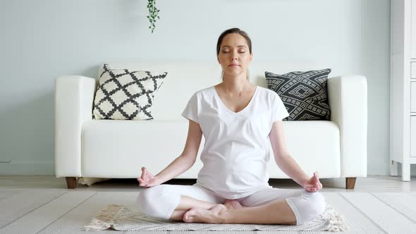 Tranquil Pregnant Woman Meditates in Lotus Pose at Home