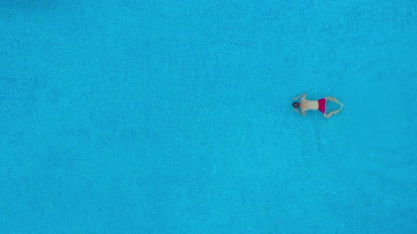 View From the Top As a Man Swims Under the Water in the Pool. Slow Motion