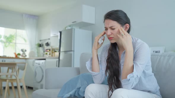 Asian beautiful unhappy woman having psychological problem sit on sofa feel frustrated and stressed