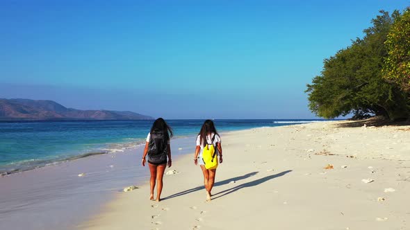 Modern beauty models on holiday enjoying life at the beach on summer white sand and blue background 