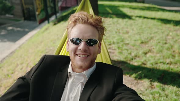 Businessman Having Video Call While Resting in Hammock