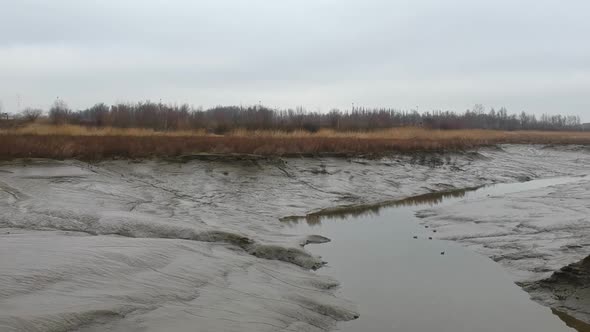 Push out rising aerial low tide dry river flood area birds mud cloudy landscape