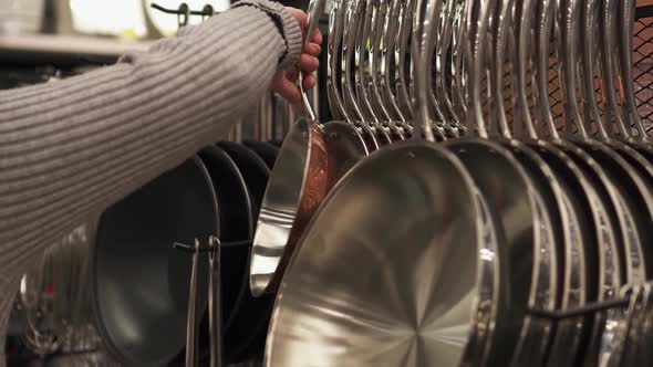 The Girl Chooses A Product In The Store The Buyer Chooses Frying Pan Buying A Frying Pan For Kitchen