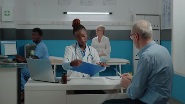Doctor Discussing with Senior Ill Patient in Healthcare Office alt