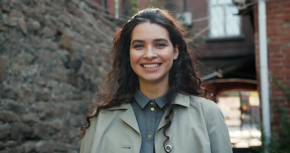 Portrait of Joyful Girl Laughing Standing Outdoors in the Street Having Fun