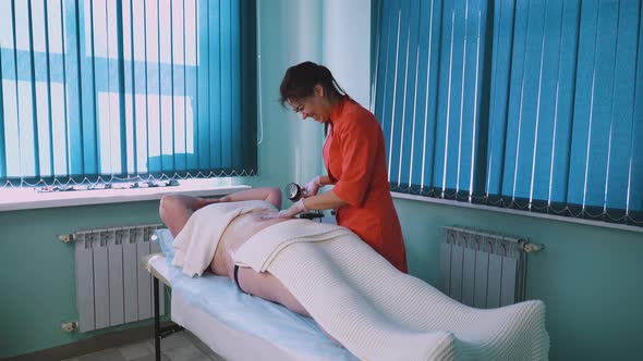 Cosmetologist Pats Large Woman Tummy Lying on Clinic Couch