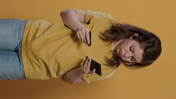 Bored Woman Doing Online Shopping Holding Smartphone Having Trouble Typing Credit Card