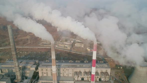 Aerial Drone View of Tall Chimney Pipes with Grey Smoke From Coal Power Plant