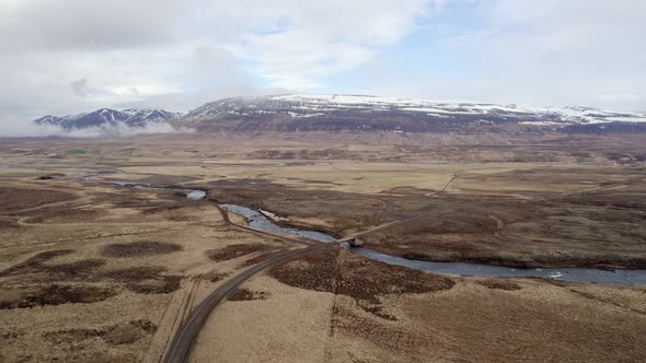 High Flying clip towards a bridge the Vididalsa River over dry autumn countryside