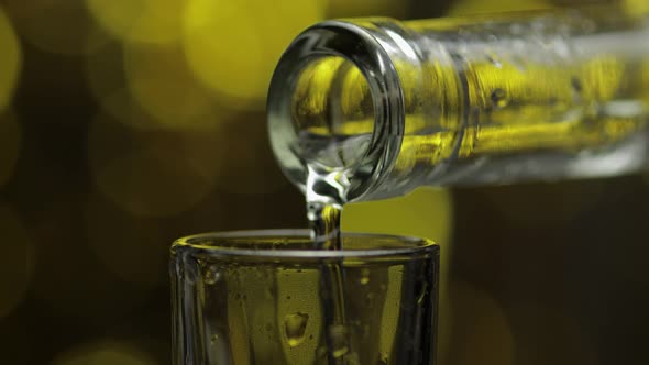 Barman Pour Frozen Vodka From Bottle Into Shot Glass Against Shiny Gold Party Celebration Background