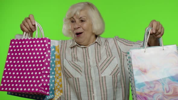 Senior Grandmother Raising Shopping Bags, Celebrating, Satisfied with Purchase, Discount, Chroma Key