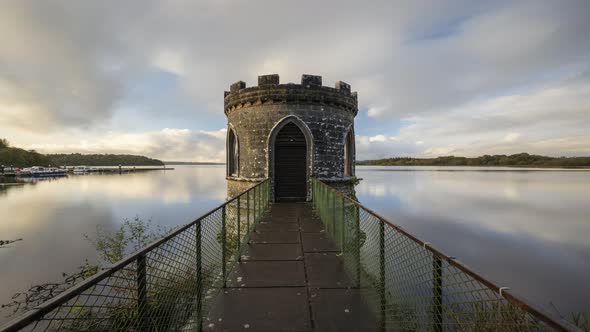 Time lapse of a medieval tower on lake with dramatic sky in rural Ireland.