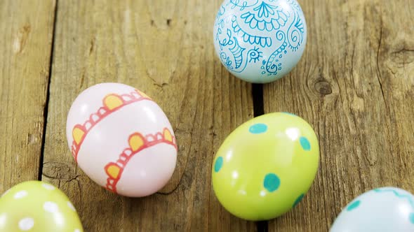 Painted Easter eggs in the nest on wooden surface