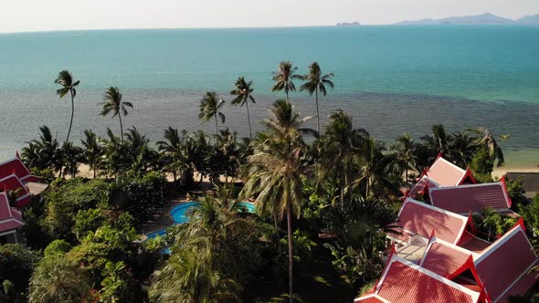 Oriental Houses on Seashore. Drone View of Lovely Oriental Cottages and Green Coconut Palms