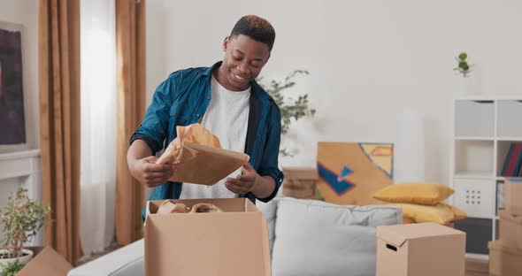 Unpacking Cardboard Boxes After Moving Man Cleans New Apartment Cluttered with Items From Previous