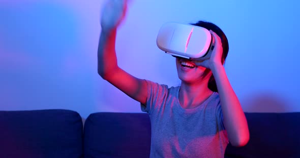 Woman play with VR device with purple and blue light