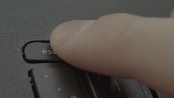 Finger Presses Escape Button on Keyboard.