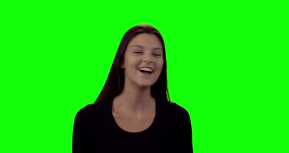 Smiling beautiful woman standing against green screen