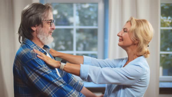 Portrait of a Happy Senior Couple Embracing Standing in Their Home