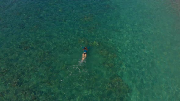 Aerial Shot of a Woman Snorkeling in a Beautiful Turquoise Sea