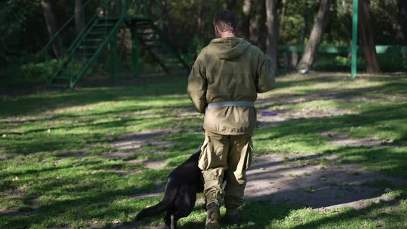 Tracking Shot Caucasian Man and German Shepherd Walking on Sunny Day Outdoors with Professional