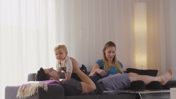 Young Family Enjoying Afternoon on Couch