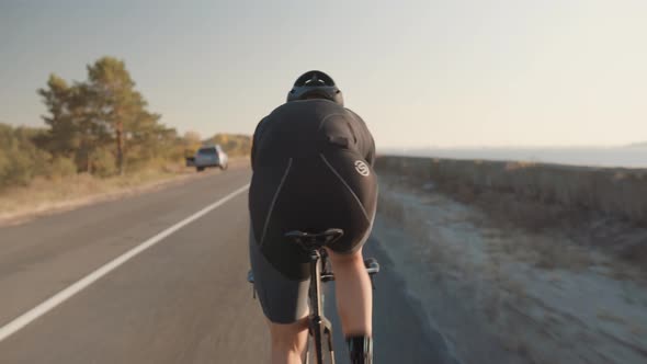 Cyclist Riding On Carbon Bike In Lycra Sportswear. Muscular Fitness Biker Cycling Workout.