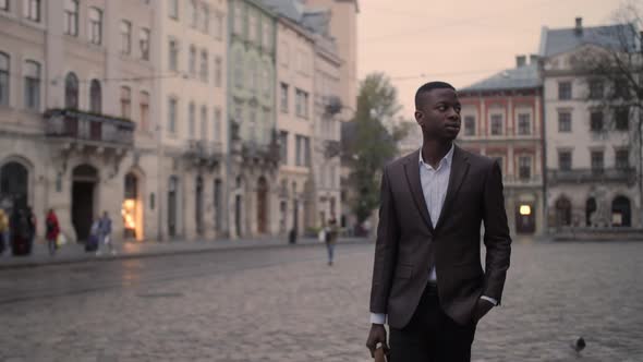 Confident Businessman Walking on Street with Briefcase