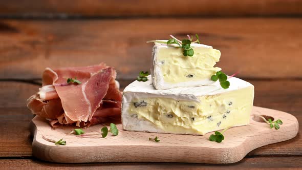 sliced jamon and blue cheese on a wooden board, breakfast