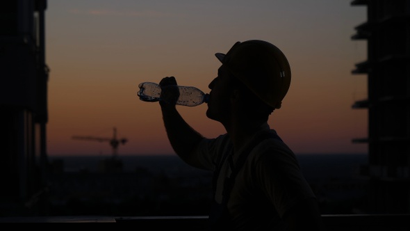 Builder drinking from the bottle.