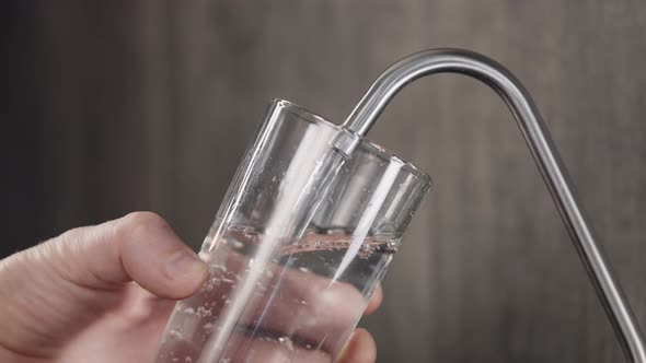 A Man Collects Drinking Water in the Kitchen