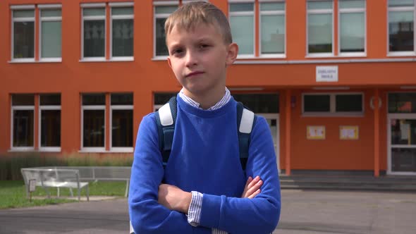 A Young Boy Shakes His Head at the Camera with His Arms Folded Across His Chest - Elementary School