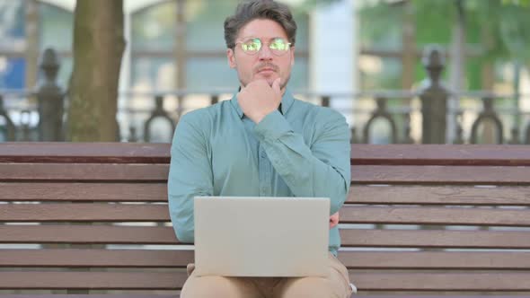 Middle Aged Man Thinking while using Laptop, Outdoor