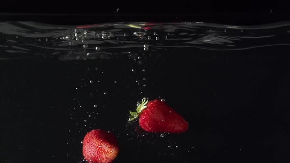 Two Strawberryes Drop Into Water in Slowmotion