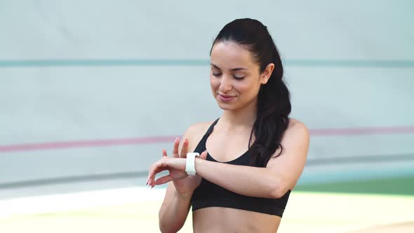 Sport Girl Checking Results on Smart Watch Outdoor. Woman Looking at Smart Watch