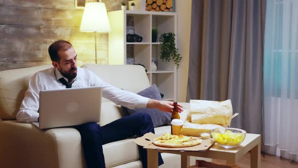 Young Entrepreneur Sitting on Couch Working on Laptop