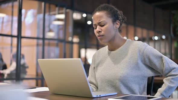 African Woman with Spinal Back Pain Working on Laptop