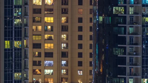 Glowing Windows in Multistory Modern Glass and Metal Residential Building Light Up at Night