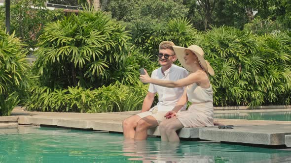 Couple on Vacation Taking Selfie Portrait at Poolside