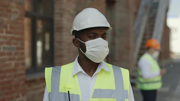 Male Engineer in Face Mask Standing at Construction Site
