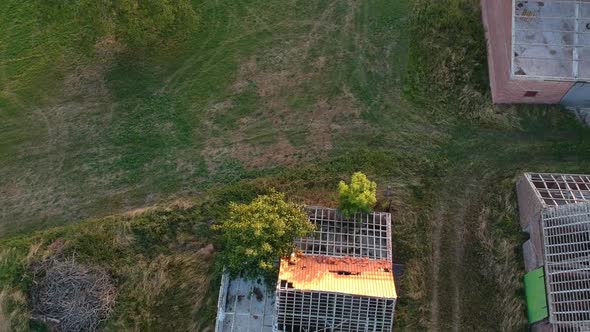 Overhead drone shot of derelict farm buildings, exposed roof framing