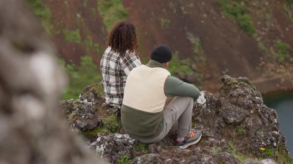 Couple Sitting Together On Rocks In Thingvellir